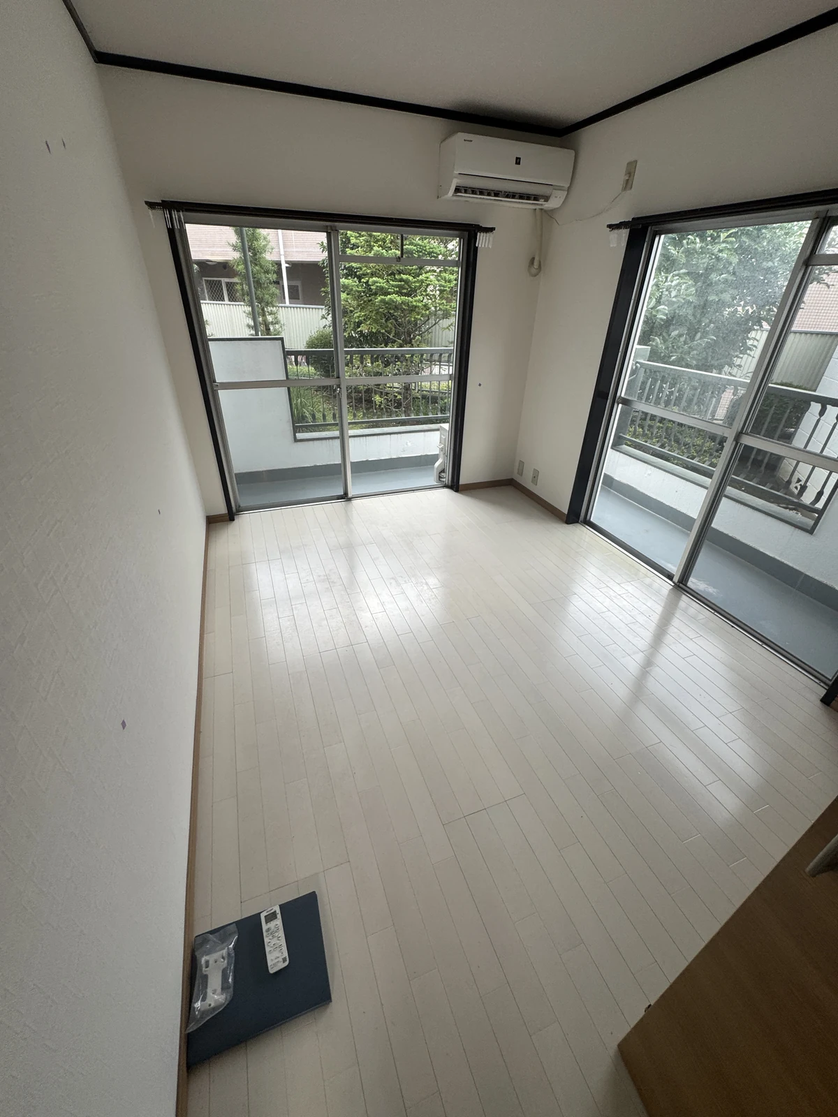 居室の床剥離ワックス施工前。既存の床と角に並ぶ二面の窓