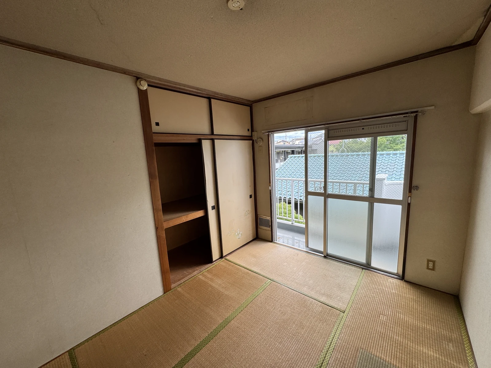 和室の施工前。既存の畳、壁紙、押入の襖が見える室内